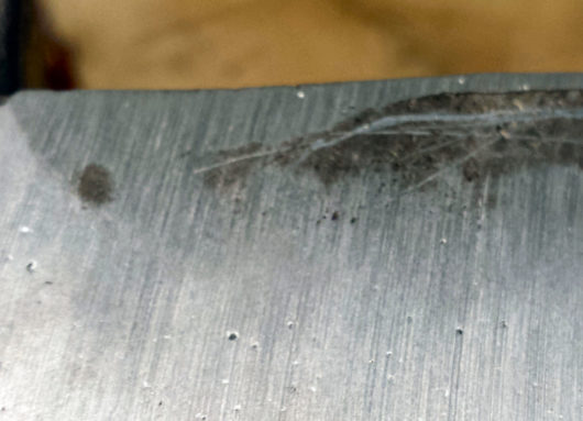 Here you can see my gantry end plate casting, the as-cast surface having been ground off by the disc sander. The vertical lines are groves left by the sanding abrasive while the small black blobs are pin hole defects. These are probably caused by small hydrogen bubbles in the melt, which would NOT have been prevented with a flux. 